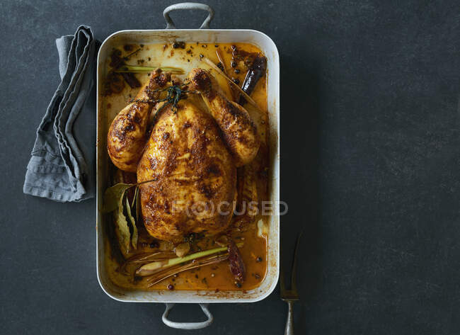 Roast chicken in a roasing tin — Stock Photo