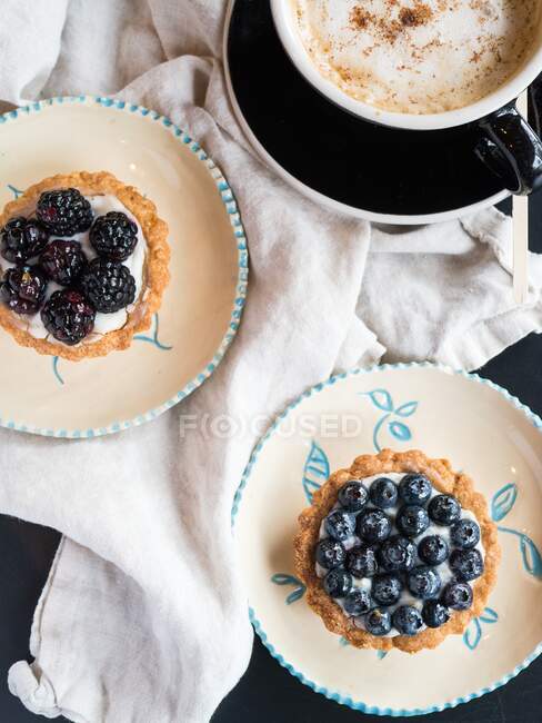 Duas tortas de baga e um cappuccino — Fotografia de Stock