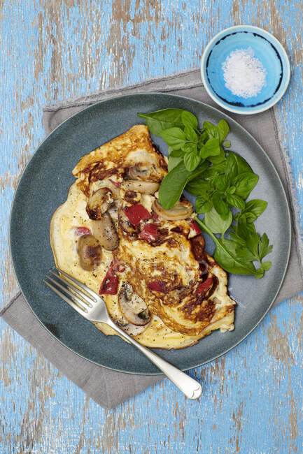 Champignons und Paprika-Omelette mit Basilikumblättern auf Teller — Stockfoto