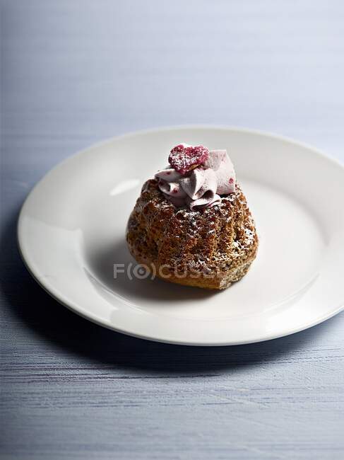 Mini gugelhupf con glaseado de azúcar, crema y frambuesas - foto de stock