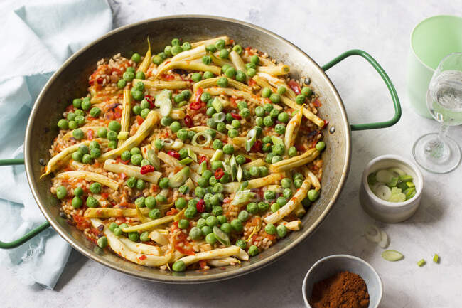 Paella vegetariana, ervilhas, feijão amarelo, pimentões vermelhos, cebolinha e páprica defumada — Fotografia de Stock
