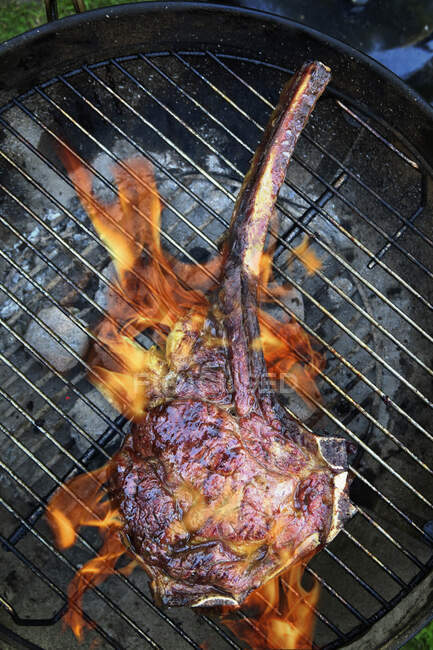 Tomahawk beef steak on a grill — Stock Photo
