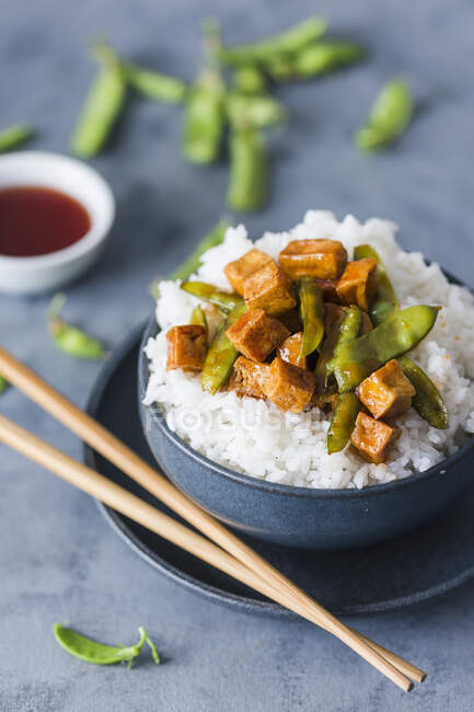 Sweet and sour tofu with mange tout on rice — Stock Photo