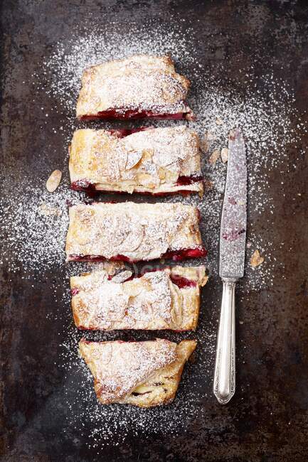 Puff pastry strudel with cherries and faked almonds - foto de stock