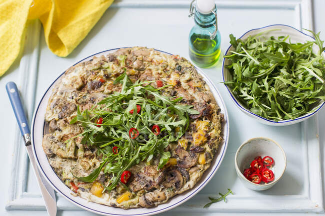 Frittata with mushrooms, red and yellow peppers, rocket and fresh chilies — Stock Photo