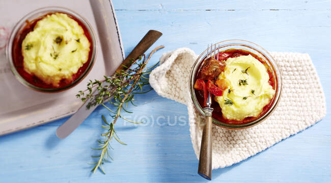 Lamb ragout with a potato topping garnished with thyme and rosemary — Stock Photo