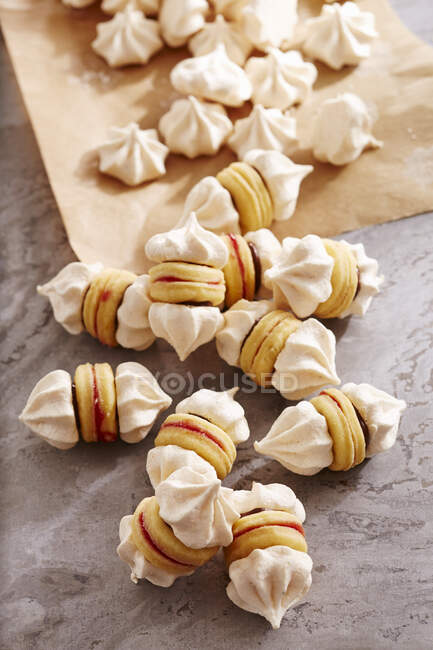 Galletas de merengue con bases de pan corto, chocolate untado y grosellas rojas - foto de stock