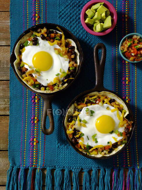 Fried eggs with vegetables in tortillas in mini pans — Stock Photo