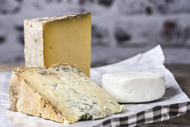 Verschiedene Käsesorten auf Papierfolie, Nahaufnahme — Stockfoto