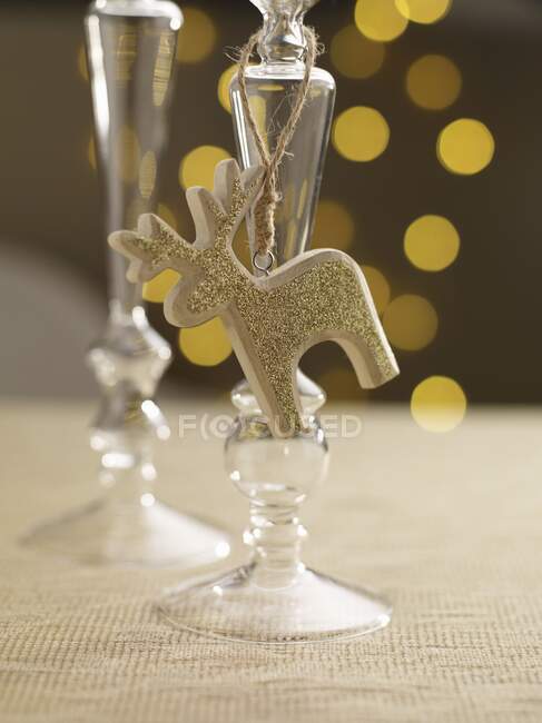 Un portacandele con una figura di renna dorata su una tavola apparecchiata a festa — Foto stock