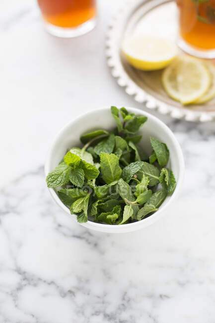 Frischer grüner Tee mit Minzblättern und Zitrone auf weißem Hintergrund — Stockfoto