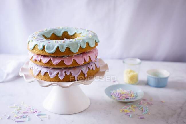 A doughnut cake with three pastel coloured glazes — Stock Photo