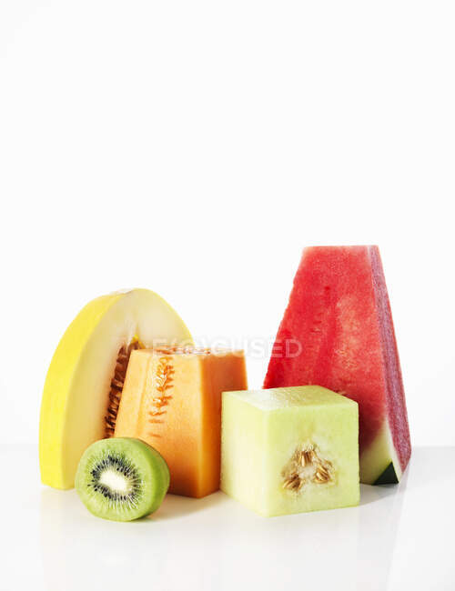 Slices of fresh ripe juicy red and green sliced whole and half cut into pieces on white background with copy — Stock Photo