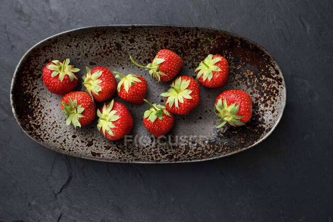 Fresas en plato de arcilla ovalada, vista superior - foto de stock