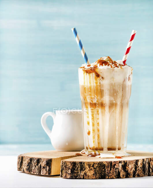 Latte macchiato with whipped cream and caramel sauce — Stock Photo