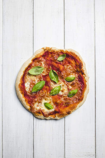 Una pizza con mozzarella y albahaca (vista desde arriba) - foto de stock
