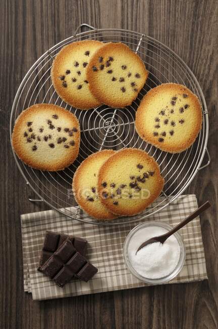 Tuiles with chocolate chips served on rack with chocolated and sugar — Stock Photo