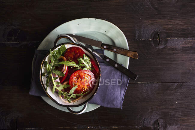 Салат из органических помидор, красный лук, травы ракеты и семян льна — стоковое фото