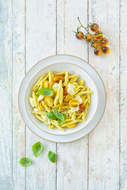 Macaroni with yellow tomatoes, mozzarella and basil — Stock Photo