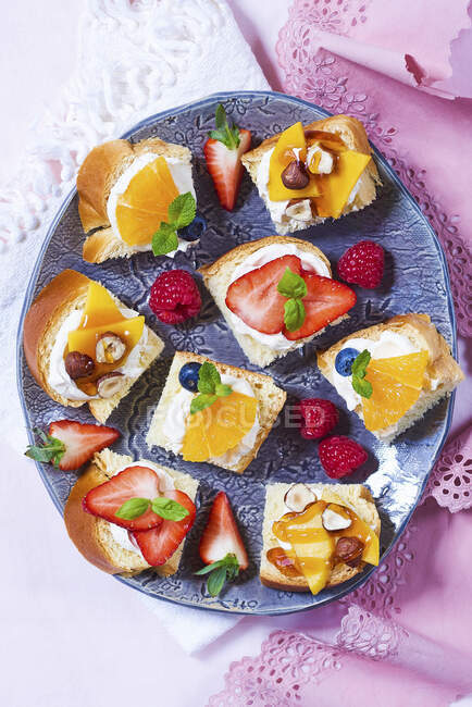 Sweet snacks with various fruit on bread with cream cheese — Stock Photo