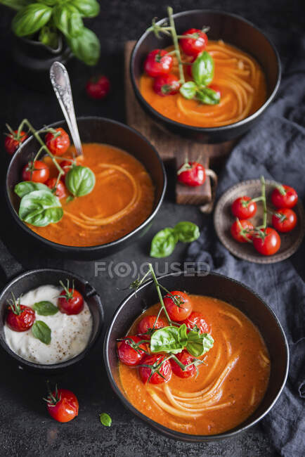Sopa de tomate cremoso con fideos y tomates cherry horneados - foto de stock