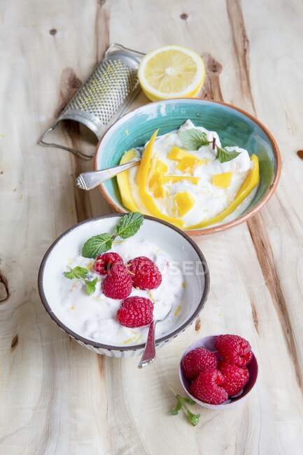 Quark desserts with raspberries and mango in bowls — Stock Photo