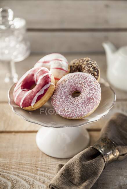 Donuts con diferentes esmaltes en un puesto de pasteles - foto de stock
