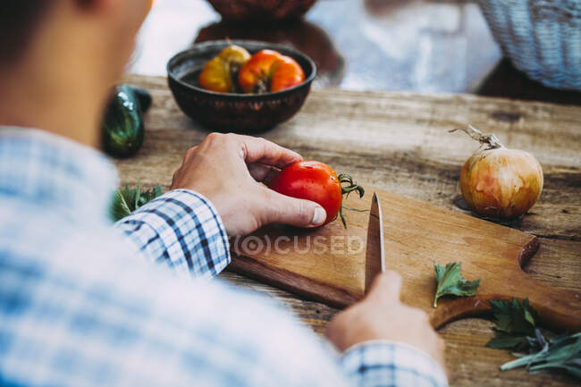 A man chopping a tomato — Stock Photo