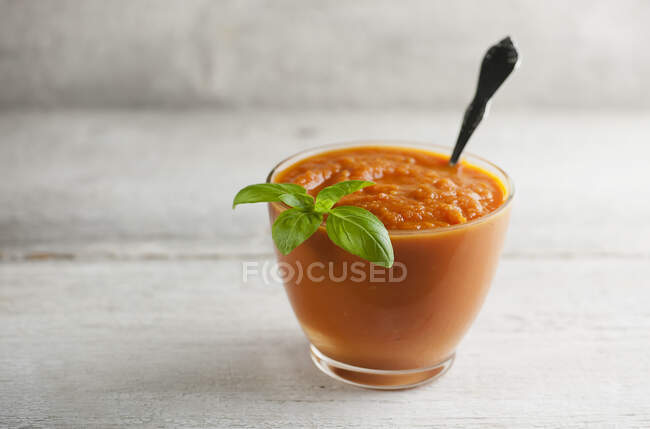 Roasted carrot soup with basil leaves — Stock Photo