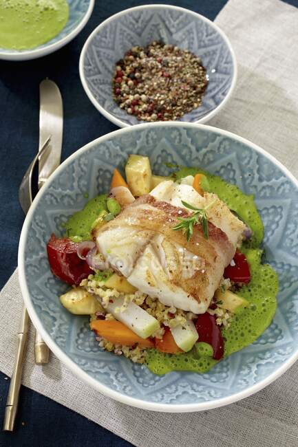 Cod wrapped in bacon on bed of couscous with vegetables — Stock Photo