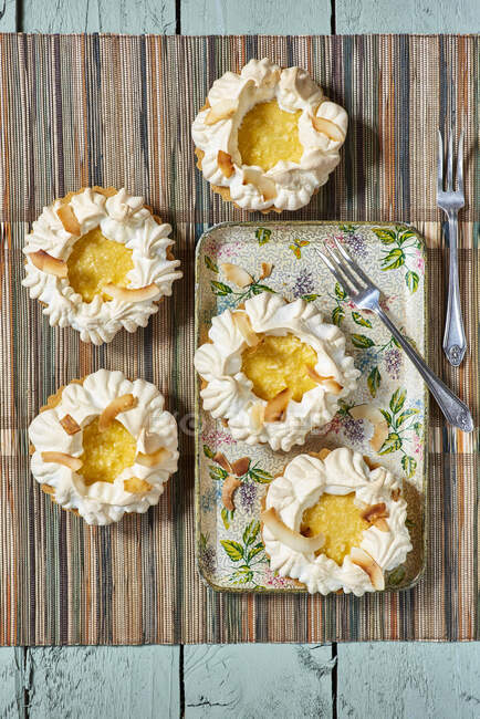 Small meringues tarts with pineapple cream and coconut flakes — Stock Photo