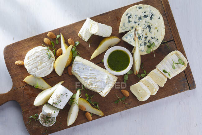 Un plato de queso con peras y almendras - foto de stock