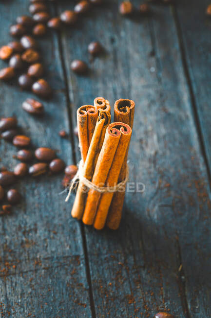 Granos de café y palitos de canela sobre madera - foto de stock