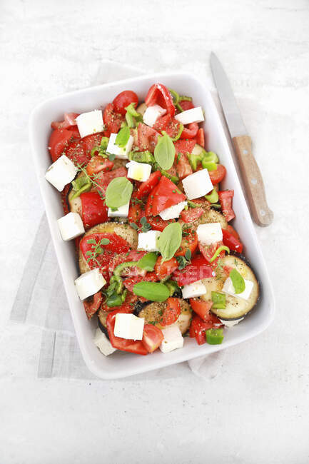 Sartén de verduras crudas listo para el horno tomates pimientos berenjenas queso feta y hierbas aromáticas - foto de stock