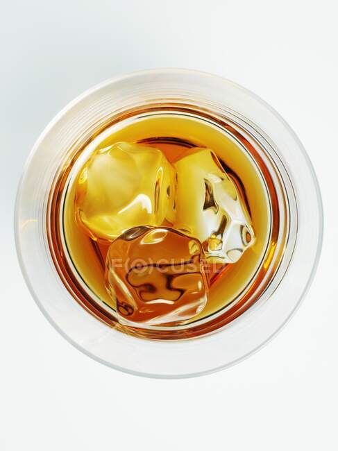 Un vaso de whisky con cubitos de hielo (vista superior) - foto de stock