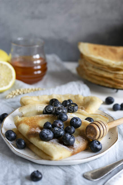 Classic French crepes topped with fresh blueberries and honey — Stock Photo