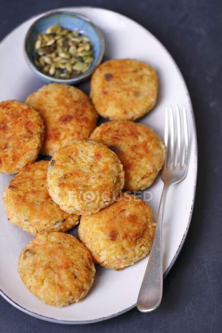Rice and carrot fritters with cheese and pumpkin seeds — Stock Photo