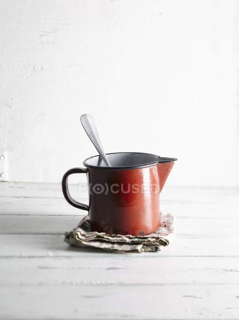 Enamelled tin can with a spoon — Stock Photo