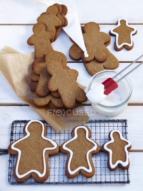 Gingerbread men cookies during decoration with icing — Stock Photo