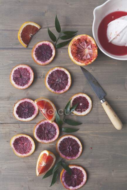 Tranches d'orange sanguine avec presse à agrumes — Photo de stock
