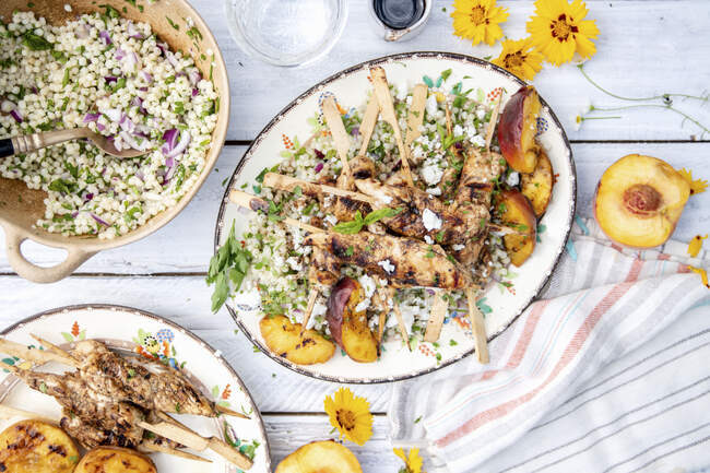 Grilled chicken kebabs with peaches and couscous salad — Stock Photo