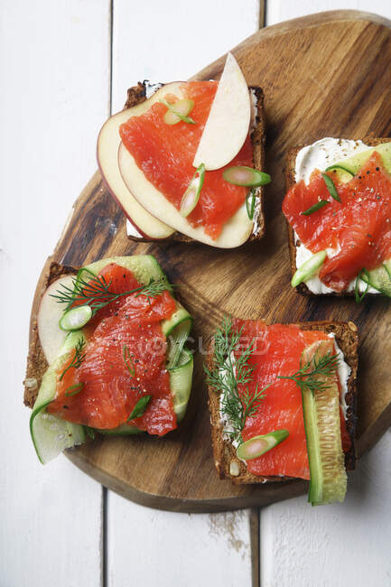 Danish traditional snack smorrebrod with salmon, cucumbers and cream cheese - foto de stock
