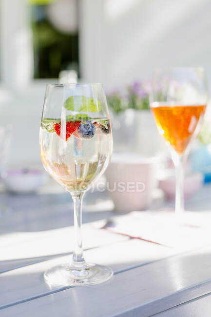 Sparkling wine cocktail with berries and mint in glass — Stock Photo