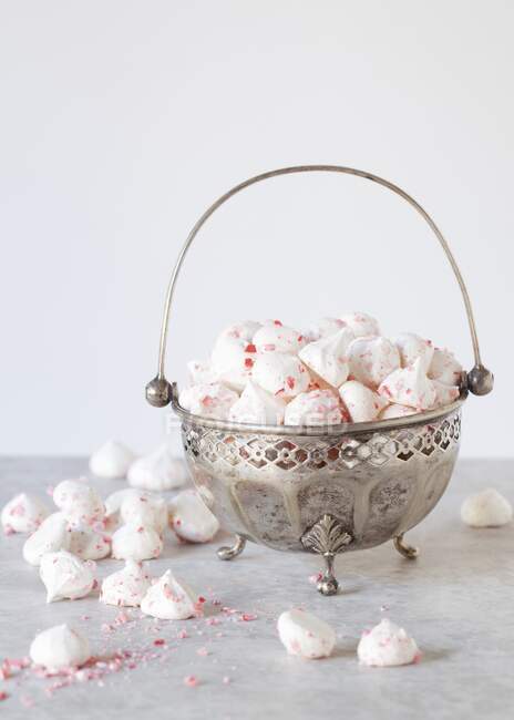 Bol en métal vintage avec poignée remplie de meringues roses saupoudrées — Photo de stock