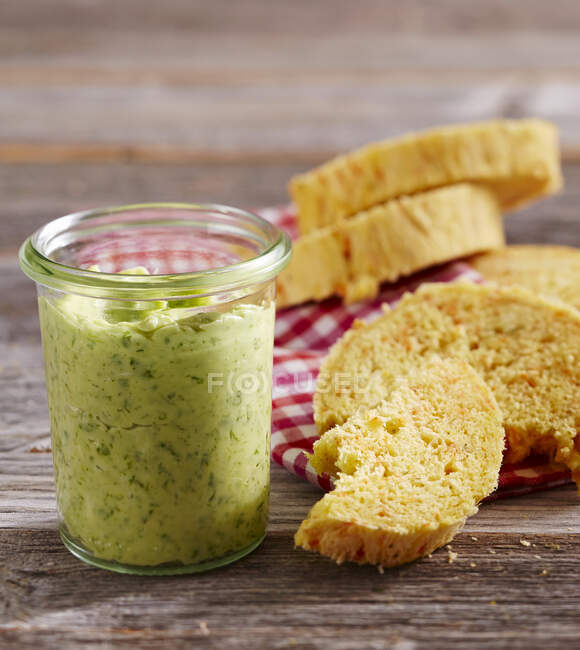 Rocket butter in a mason jar with carrot and chervil bread — Stock Photo