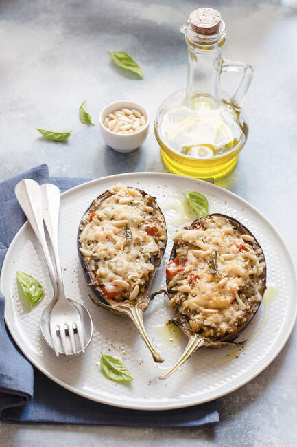 Stuffed eggplant halves with grated cheese served on plate — Stock Photo