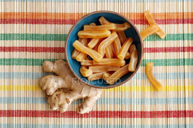 Ginger fruit gums and a fresh ginger root — Stock Photo