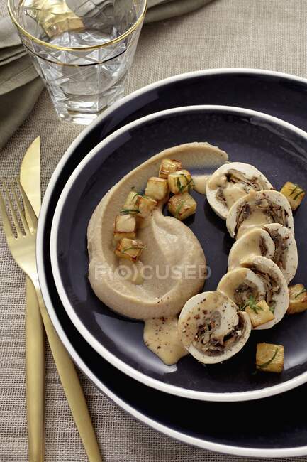 Chicken roulade filled with mushrooms served with chestnut pure and fried diced celeriac — Stock Photo