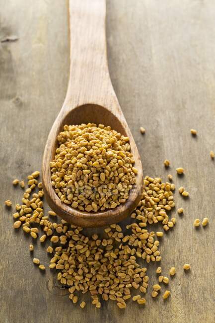 Whole buckwheat bran seeds on wooden spoon — Stock Photo
