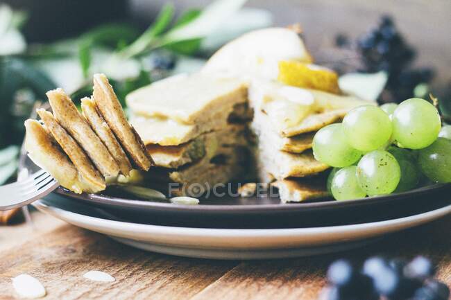 Stacked pancakes with grapes and almond flakes — Stock Photo